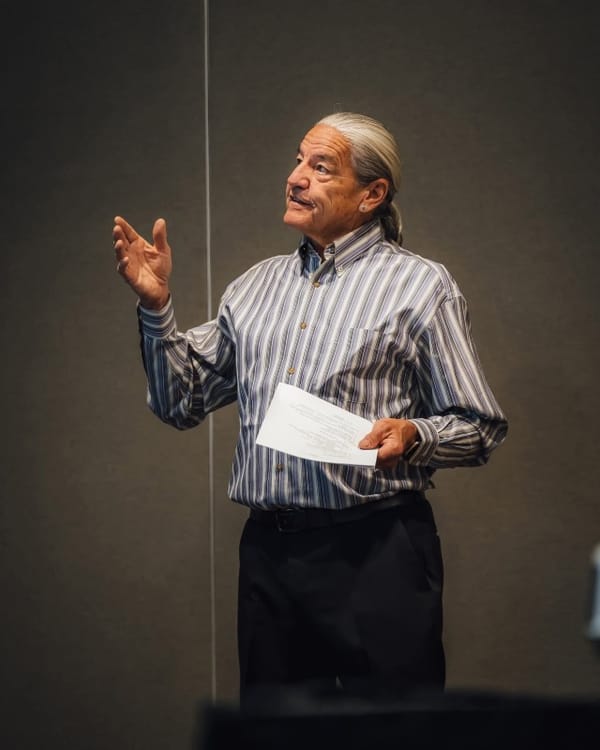 Dramatic photo of Dallas Gudgell standing in the shadows and light.